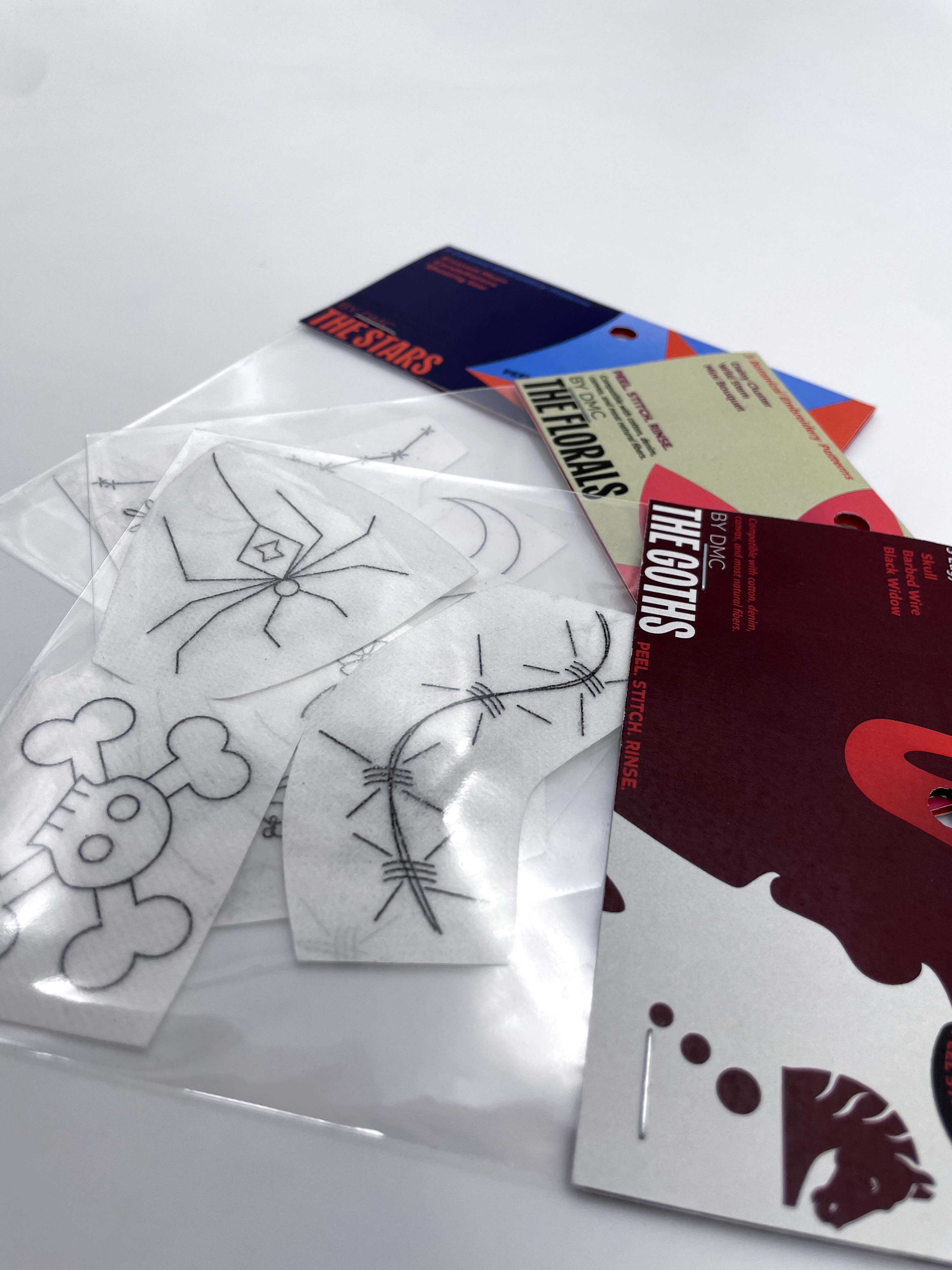 Close up shot of three header/polybag packages containing embroidery patterns.