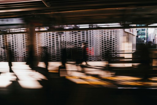 a group of people walking down a street next to a building