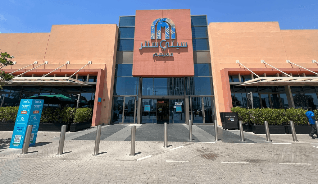  Entrance to the mall in Dubai Production City, featuring modern architecture and vibrant signage.