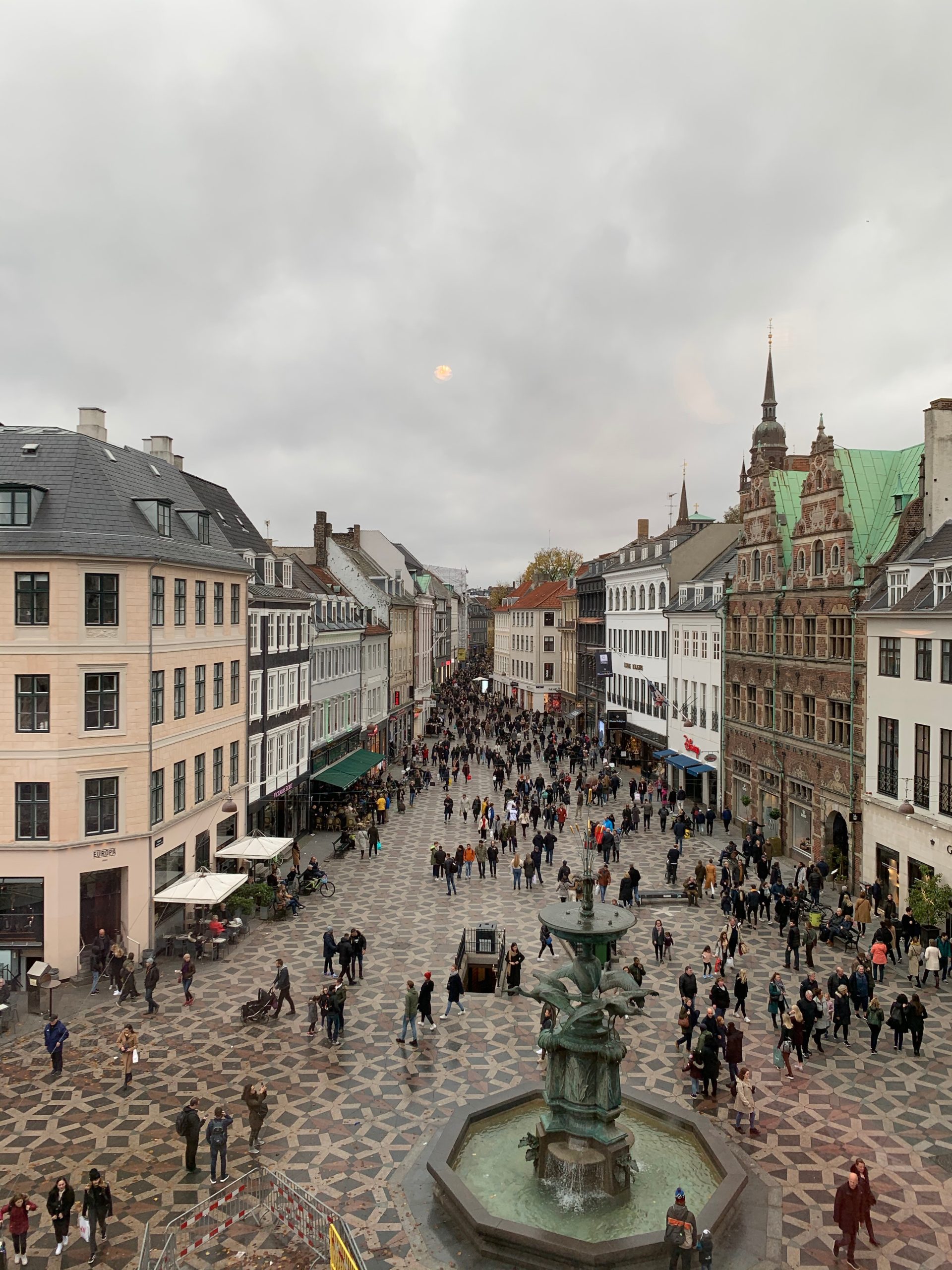 Aerial view of a crowded pedestrian shopping street leading to an ornate green-roofed building
