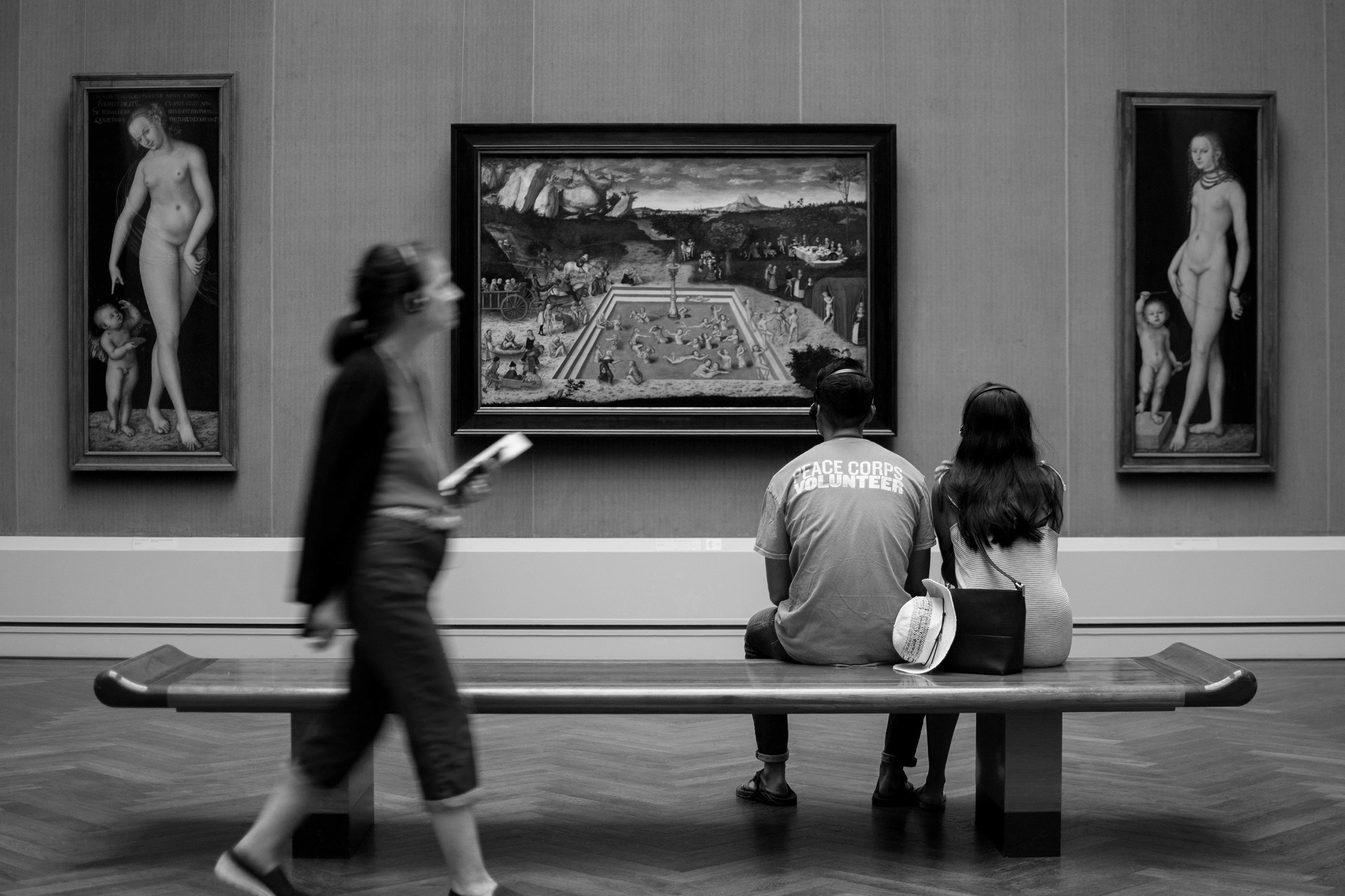 Museum visitors observing Renaissance paintings in a gallery