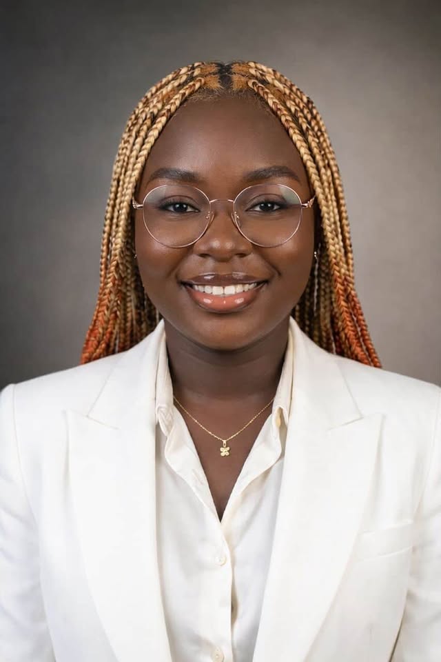 smiling woman sitting on grass during daytime