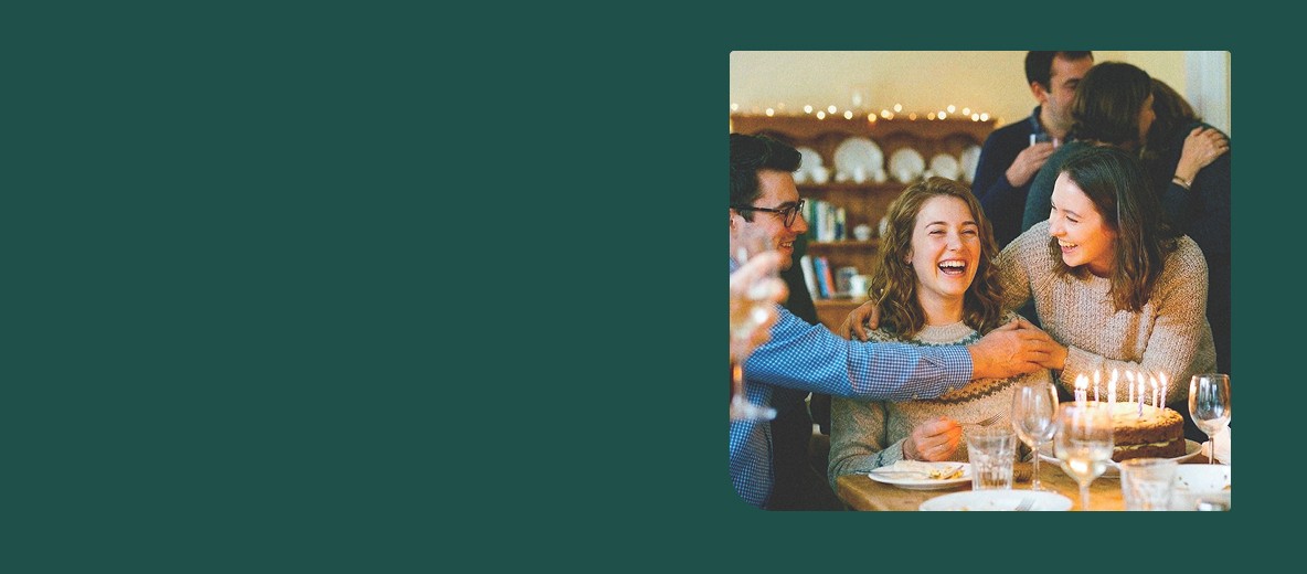 four boys laughing and sitting on grass during daytime