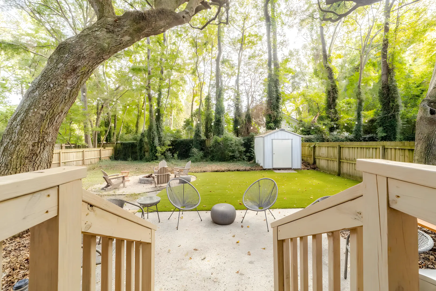 Steps down from the back deck to the fire pit and lawn under the live oaks