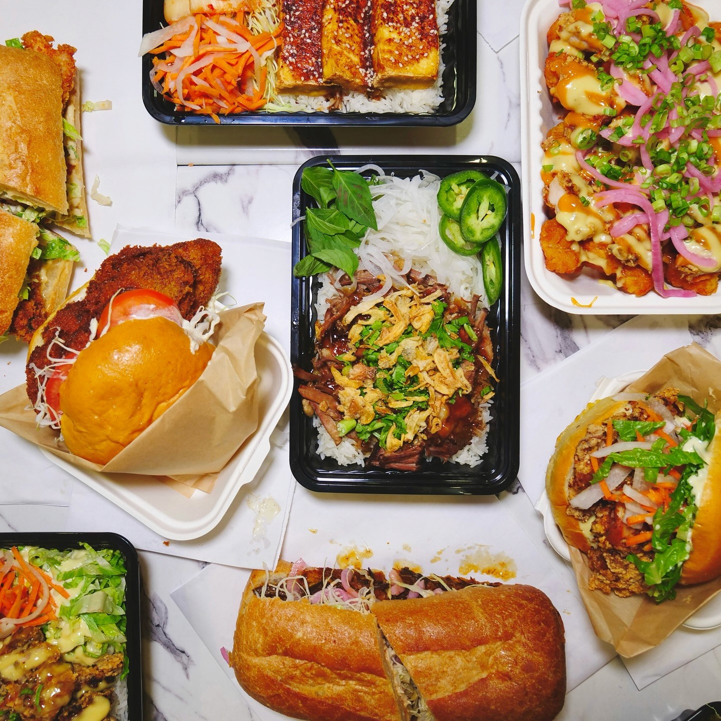 A close-up of Little Kirin’s signature Pho Sandwich, featuring slow-braised beef, fresh herbs, crispy shallots, and a side of fragrant pho broth for dipping, served on a crusty ciabatta roll. Perfect for fans of Vietnamese-inspired flavors in NYC.