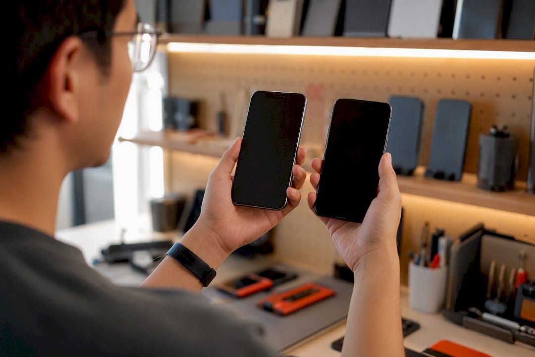Hands holding two smartphones for rendering test