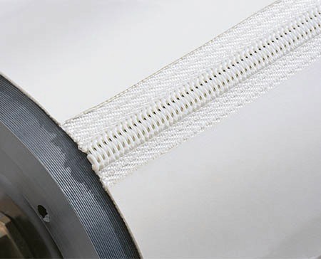 Orange vibration motor with silver end caps and connector cable.