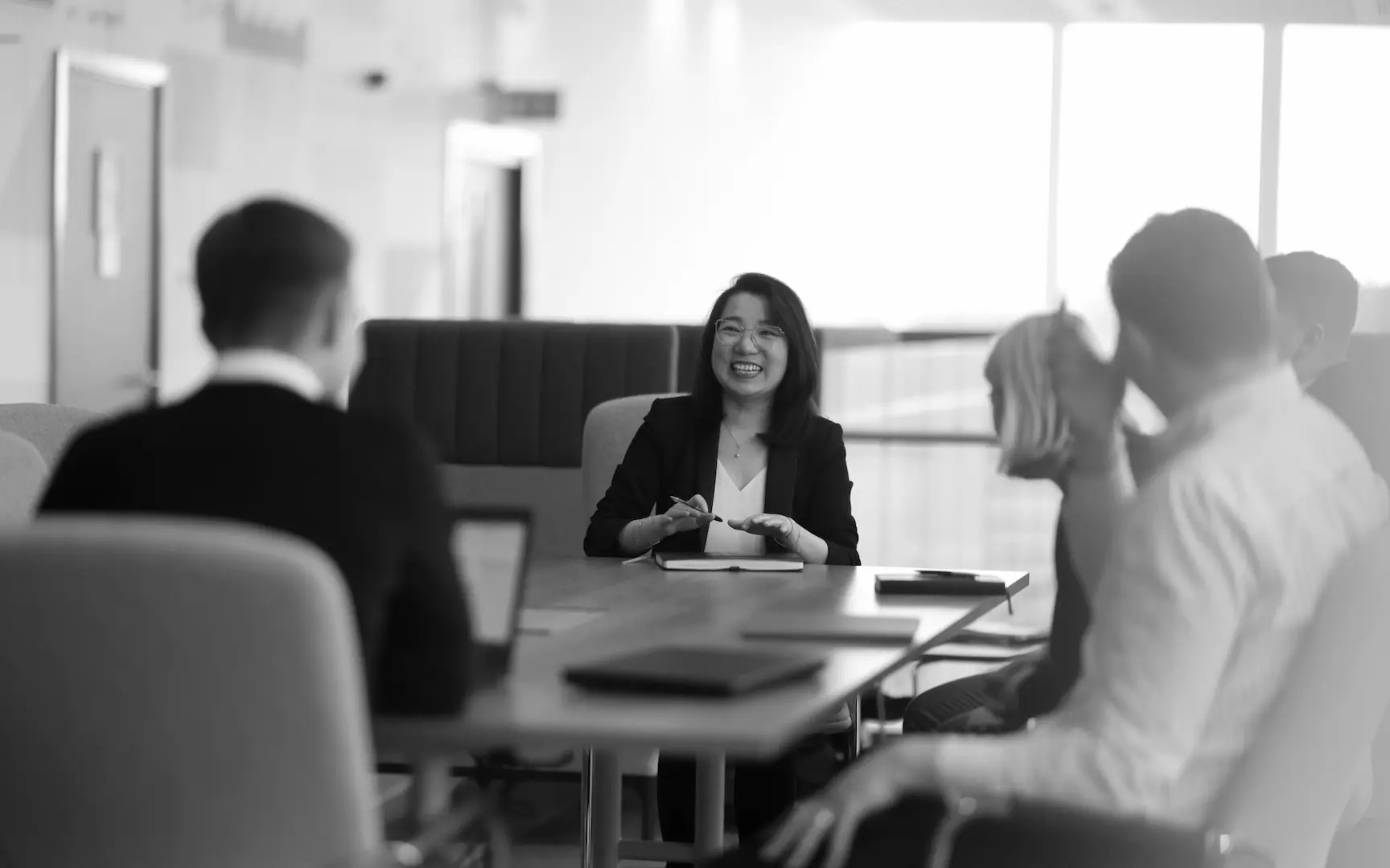 A black and white photo of the EverQuest investment team smiling in a meeting