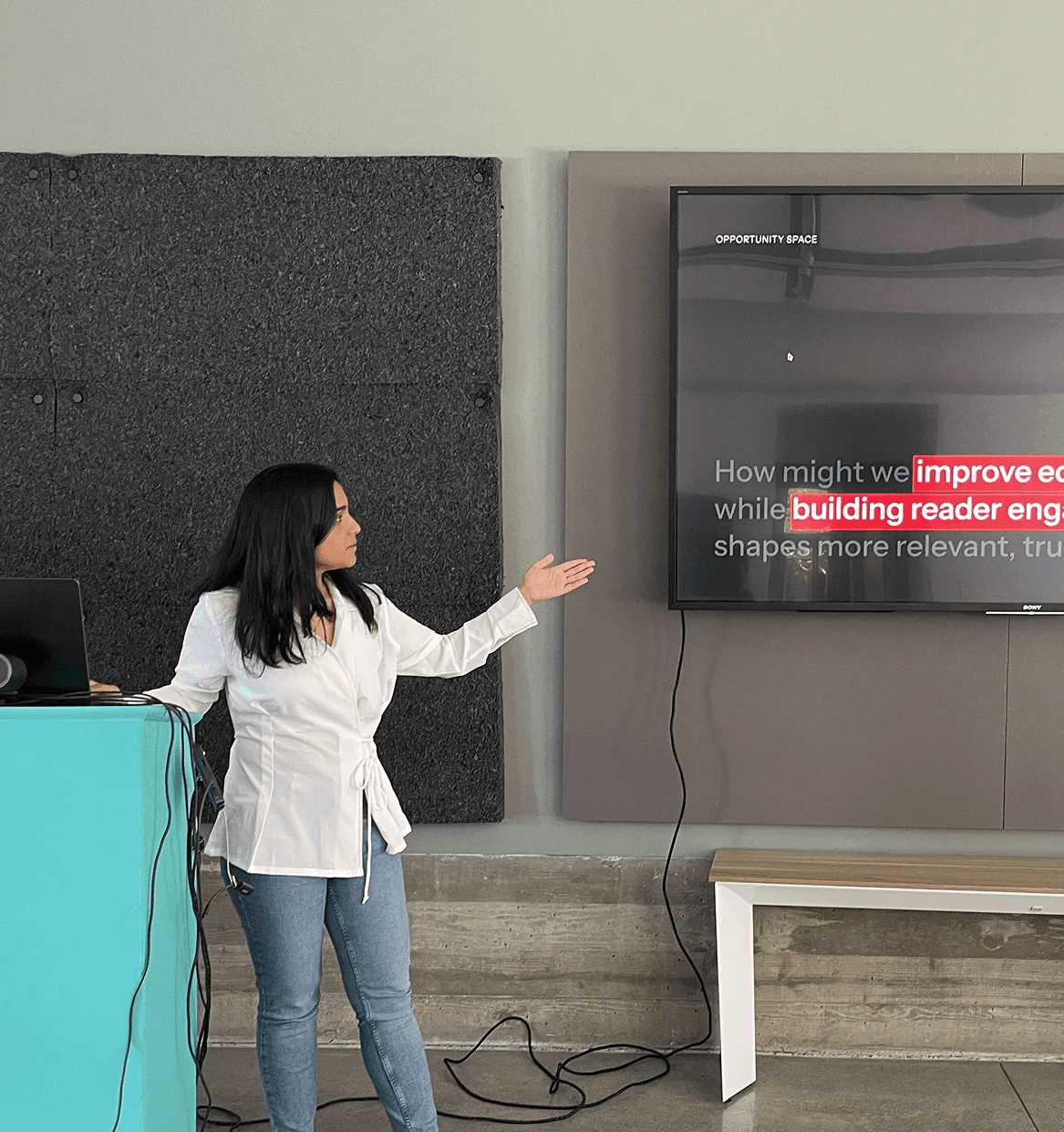 Studio portrait of a young person with blond hair, wrapped in translucent orange fabric against a blue background