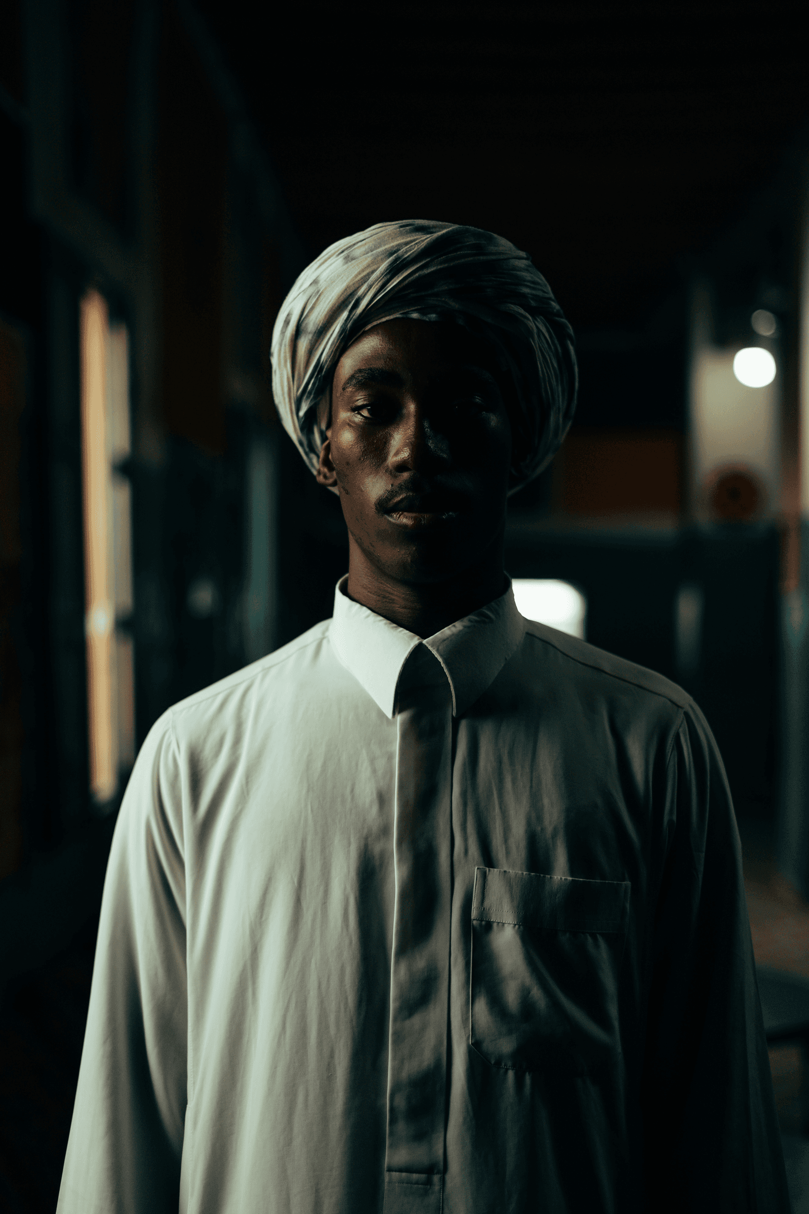 Dark man wearing white shirt.