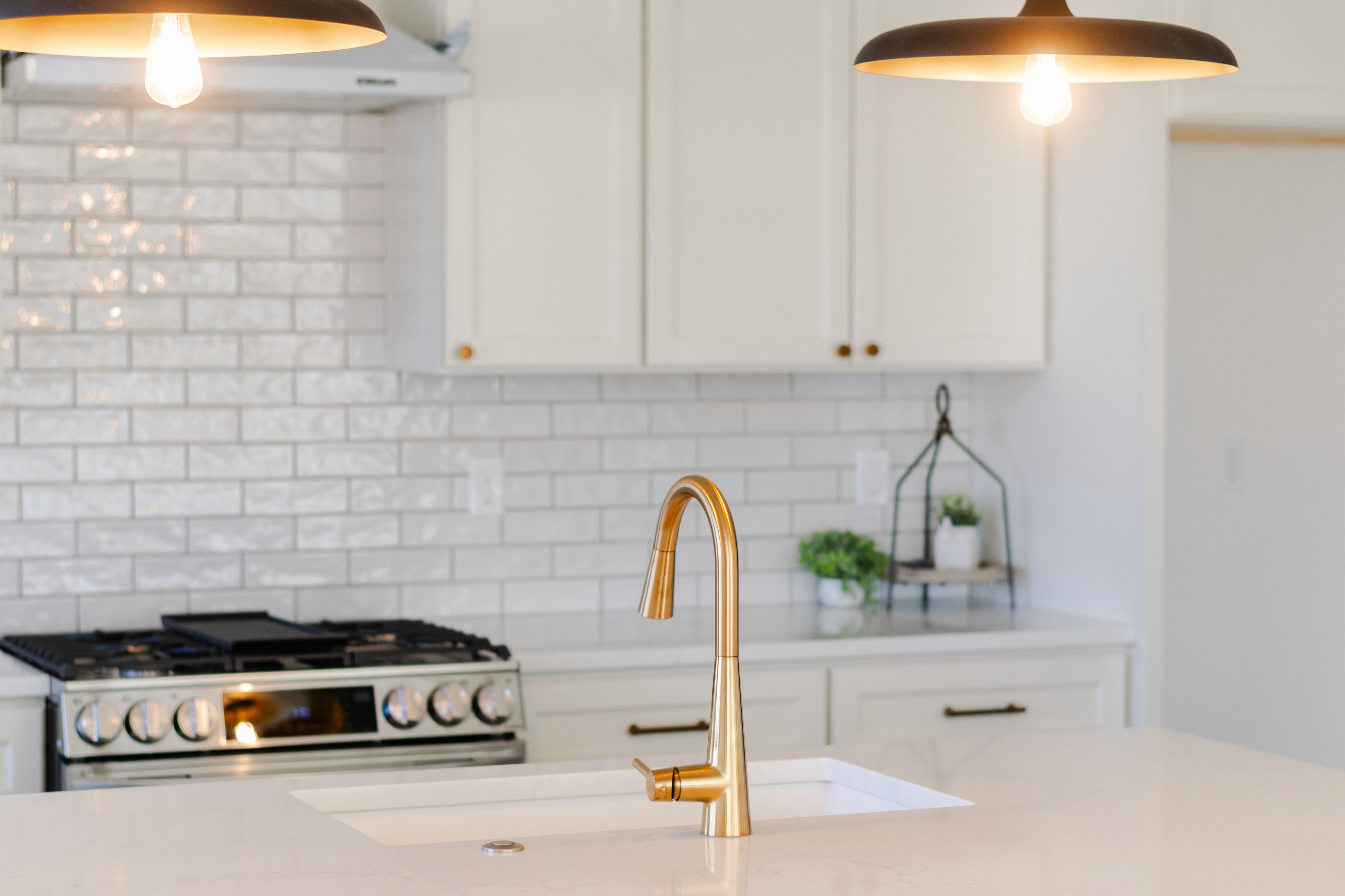 Brass faucet and lighting details in the kitchen.