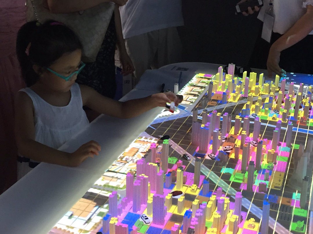 People walking on a colorful, curved walkway with city views.