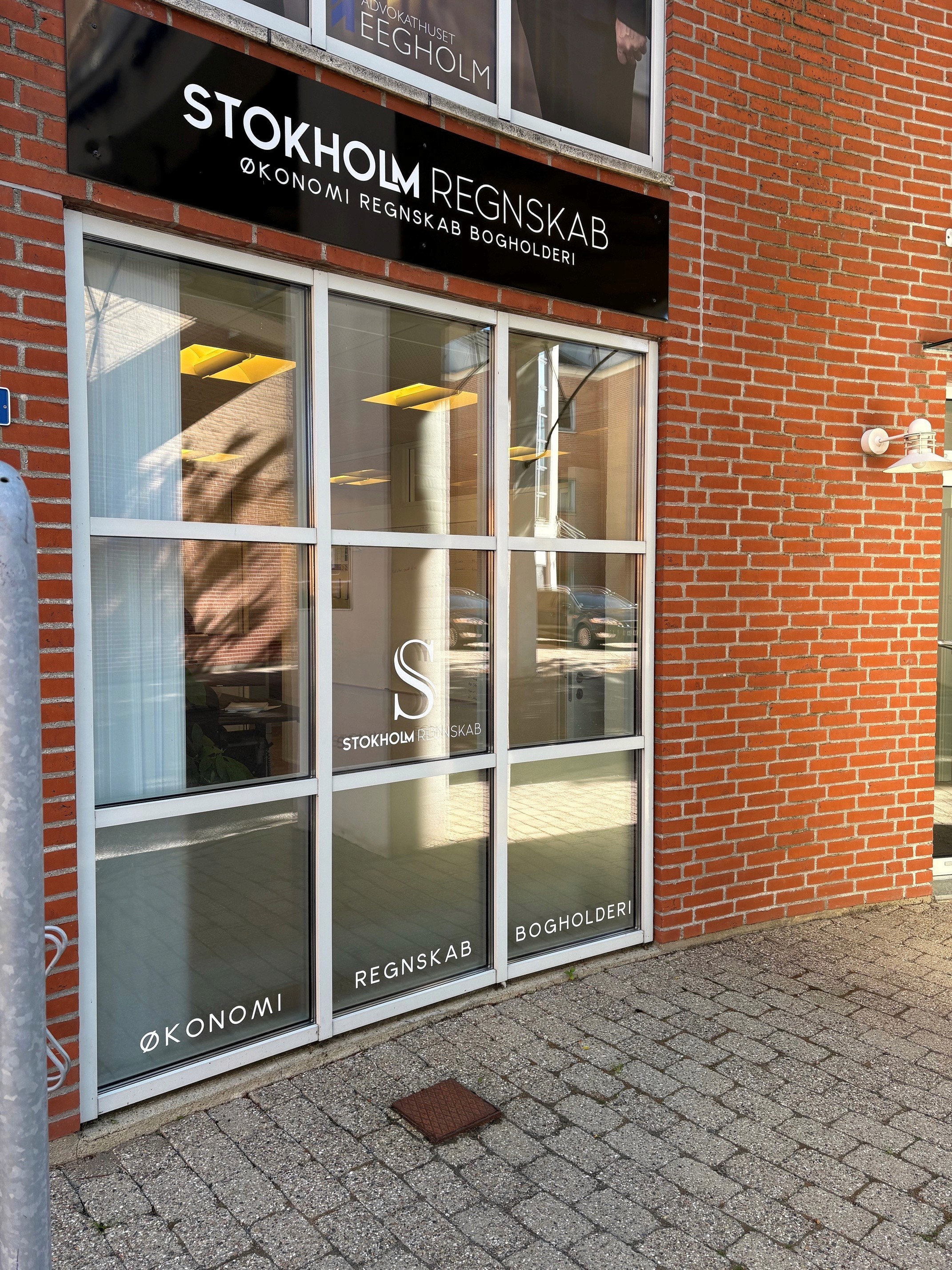 Indgang og facade til Stokholm Regnskab i Herning med kontorskilt og vinduesfolie for regnskab og bogholderi