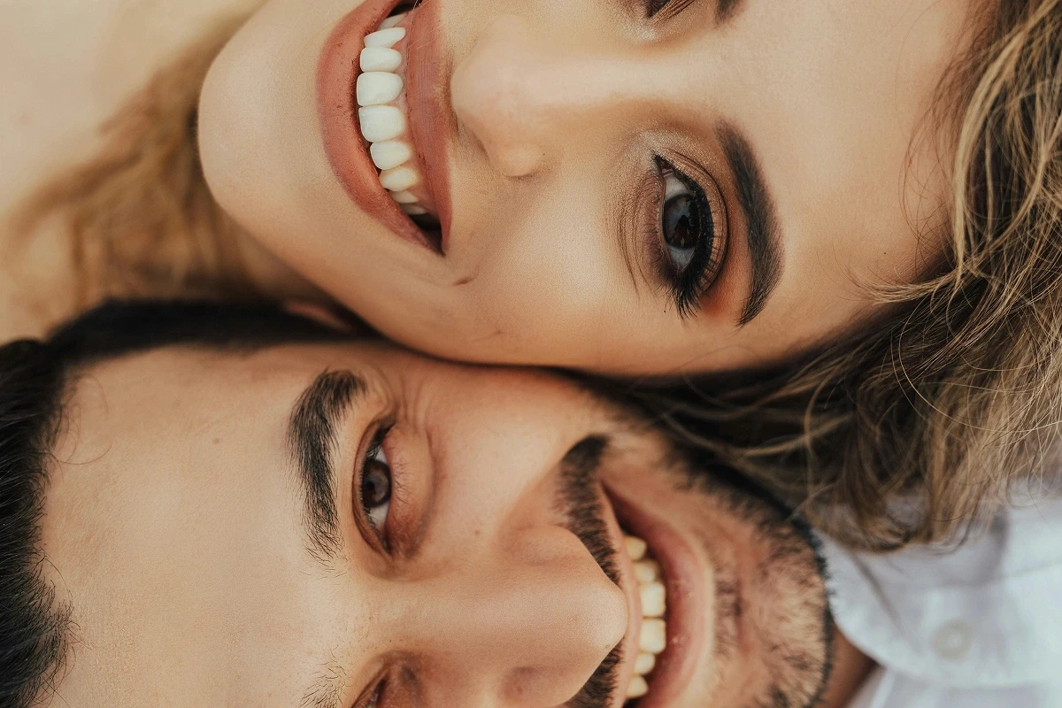 Bride and groom smiling together in a lush green garden