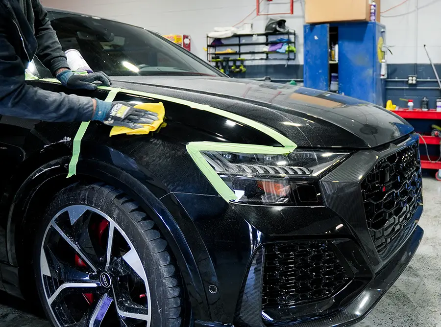 Auto body technician performing paint correction on vehicle at Simi Valley auto body shop
