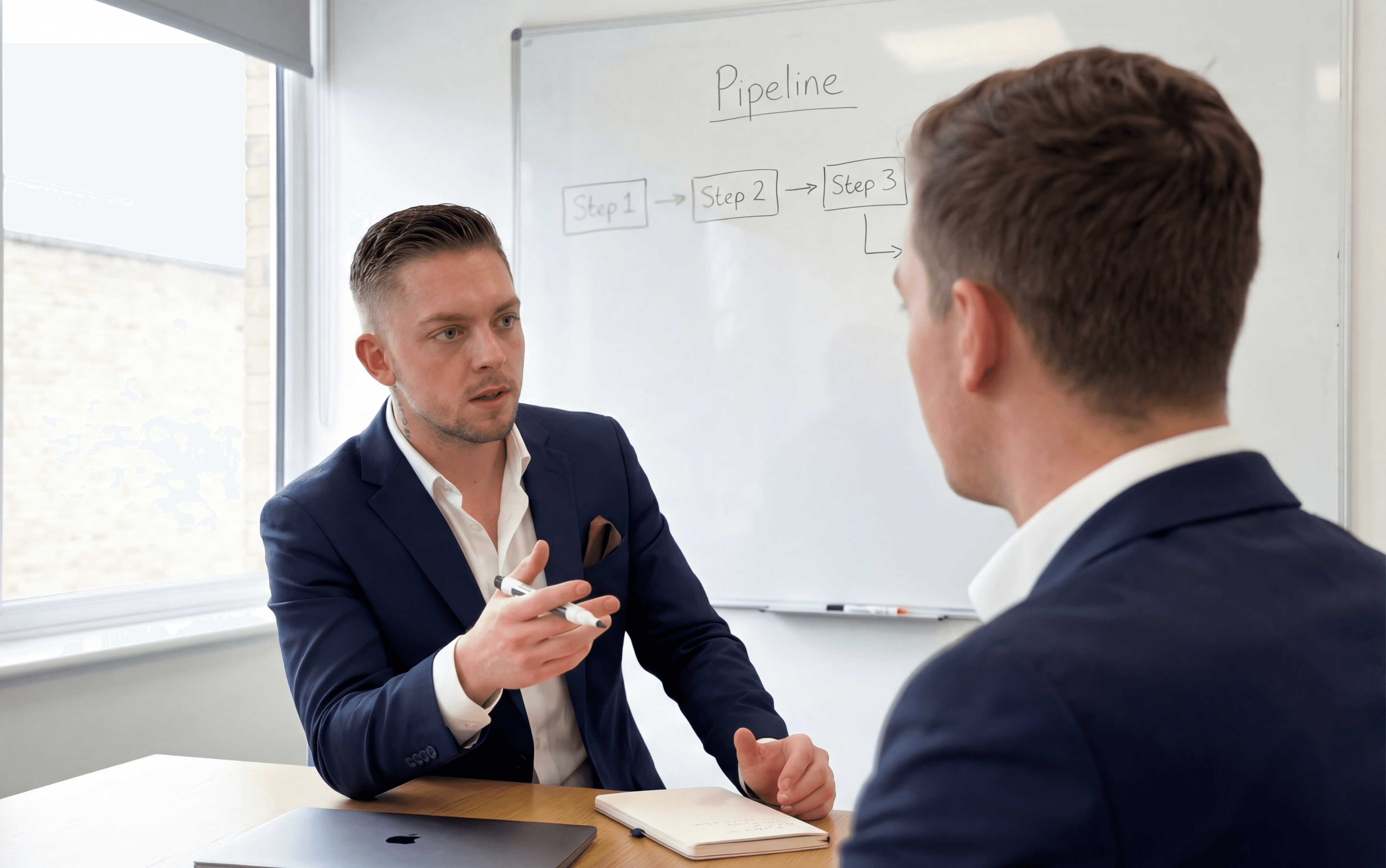 two men facing each other while shake hands and smiling