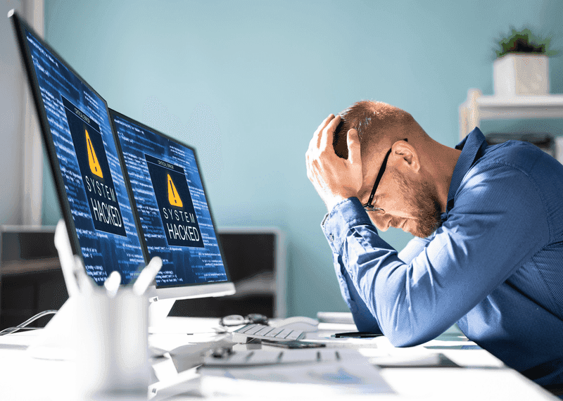 Man with System Hacked warning on his computer