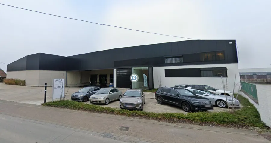 Bedrijfsgebouw van AAQUA met geparkeerde voertuigen