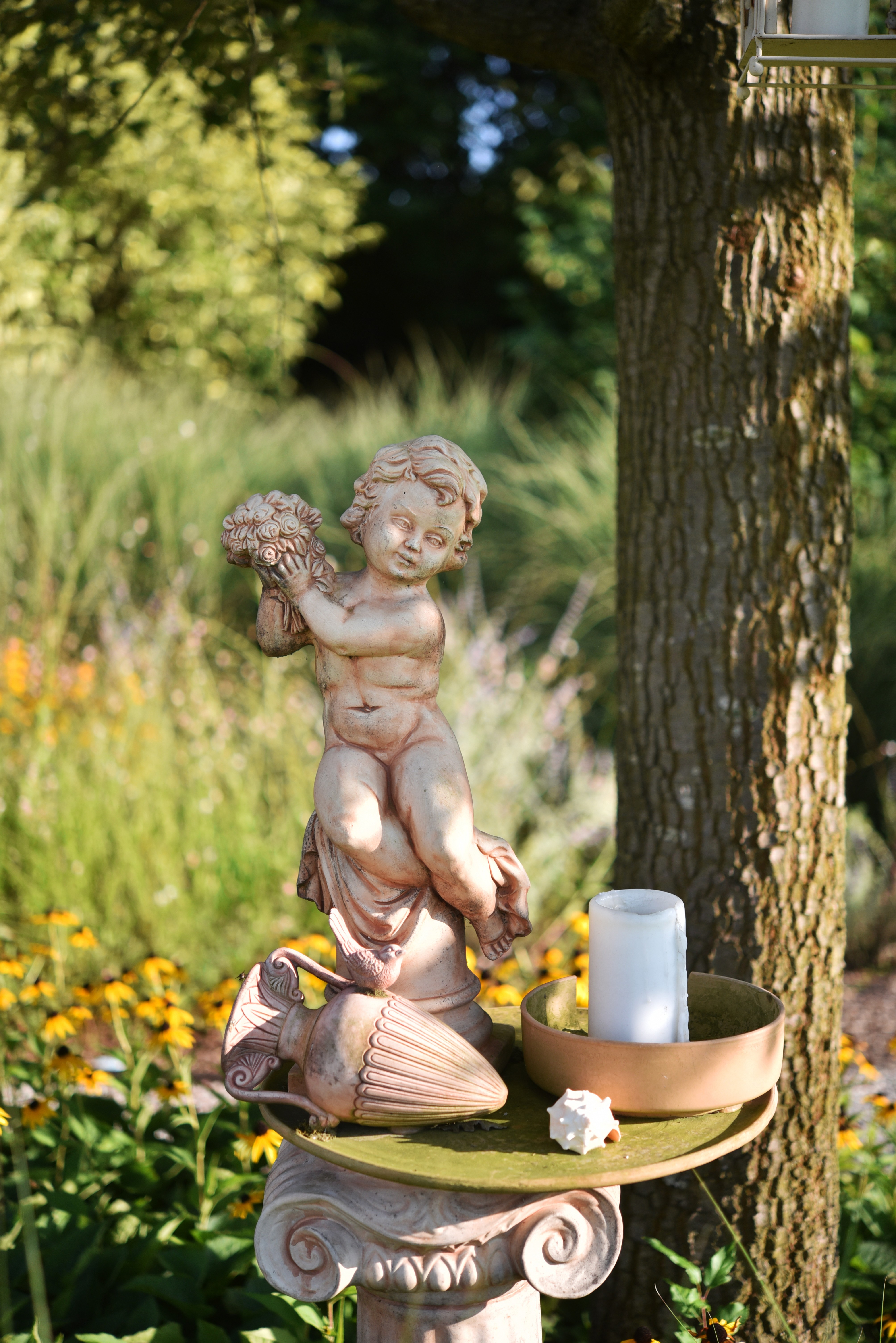 immagine di una statua di un angioletto nel giardino