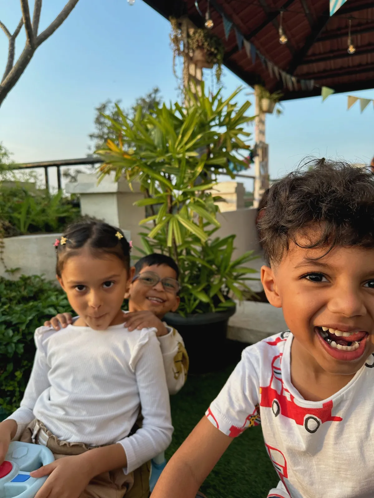 Ahana, Kaai and Arjun posing for a photo in the nebula montessori garden