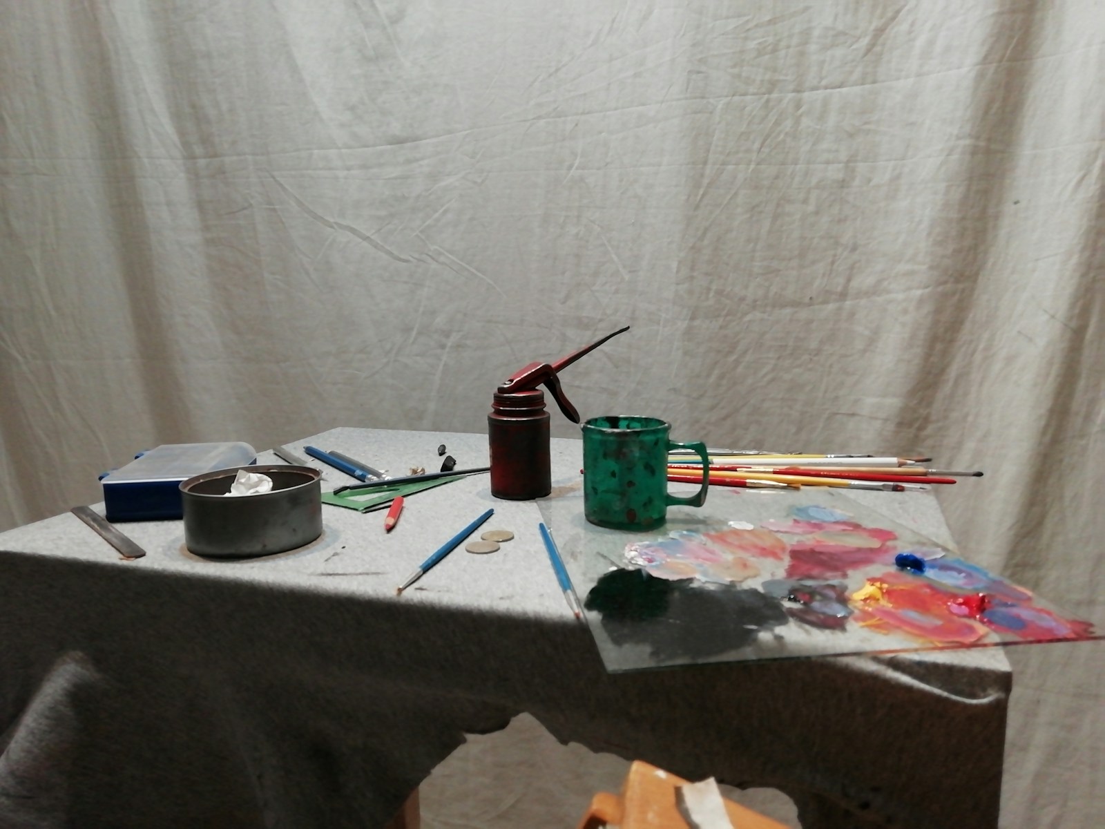 A green bottle resting on a white work table