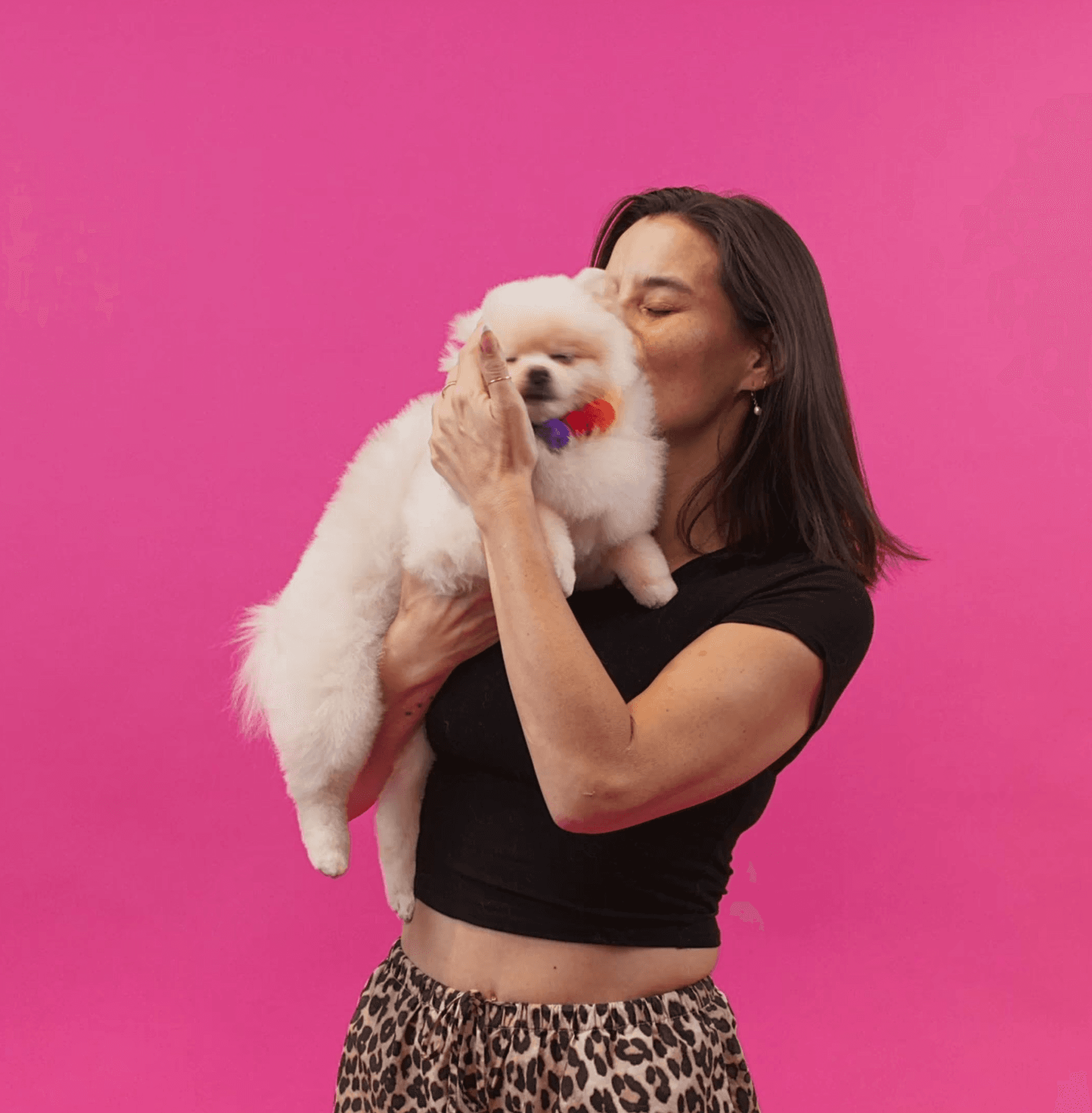 Happy woman hugging her small white dog to reflect warmth, connection, and gentle grooming experience.