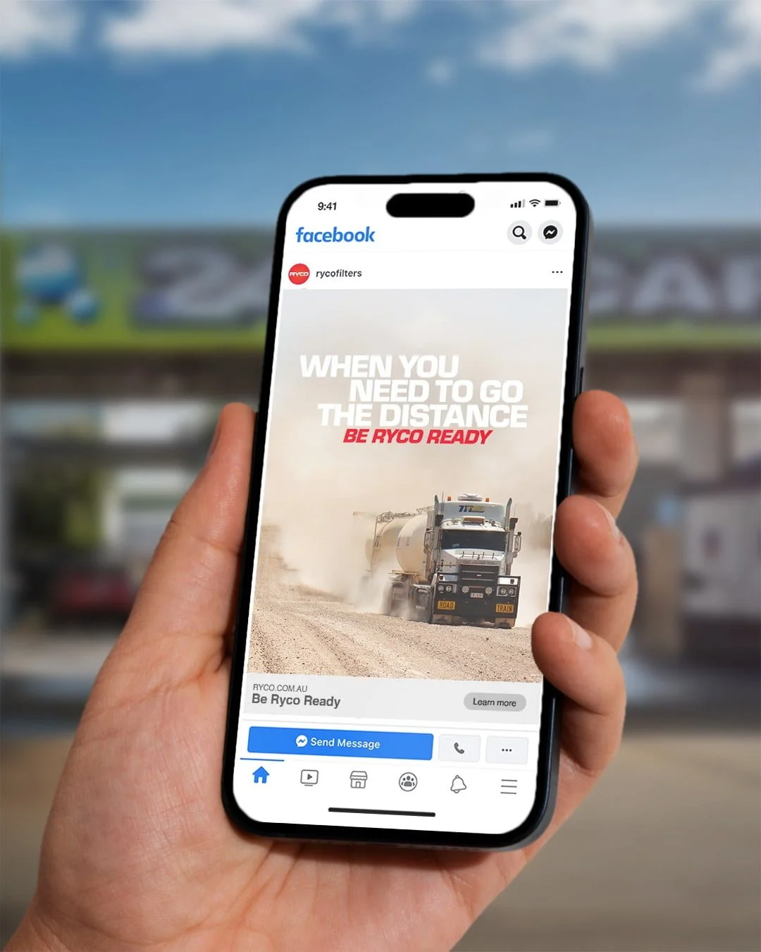 Phone showing a Ryco Facebook ad: 'When you need to go the distance. Be Ryco ready.' with a road train on a dusty road