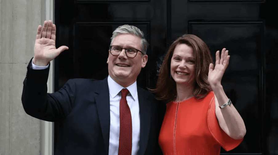 Keir Starmer (left) and his wife face the cameras after Starmer’s victory in London on July 5th. (Photo Courtesy of Henry Nicholls | CNBC) 