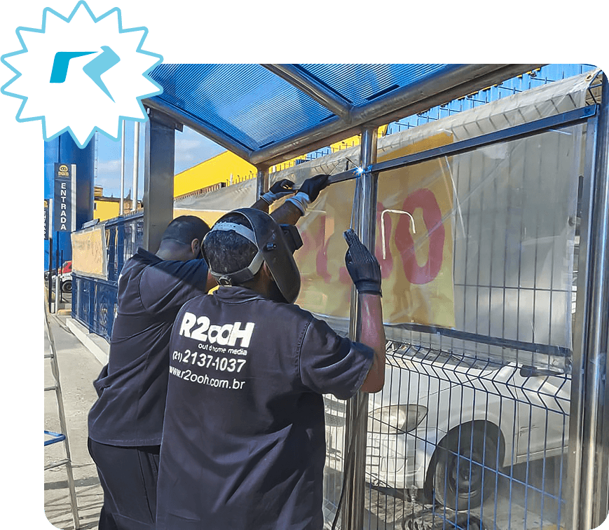 Equipe R2OOH em instalação de mídia