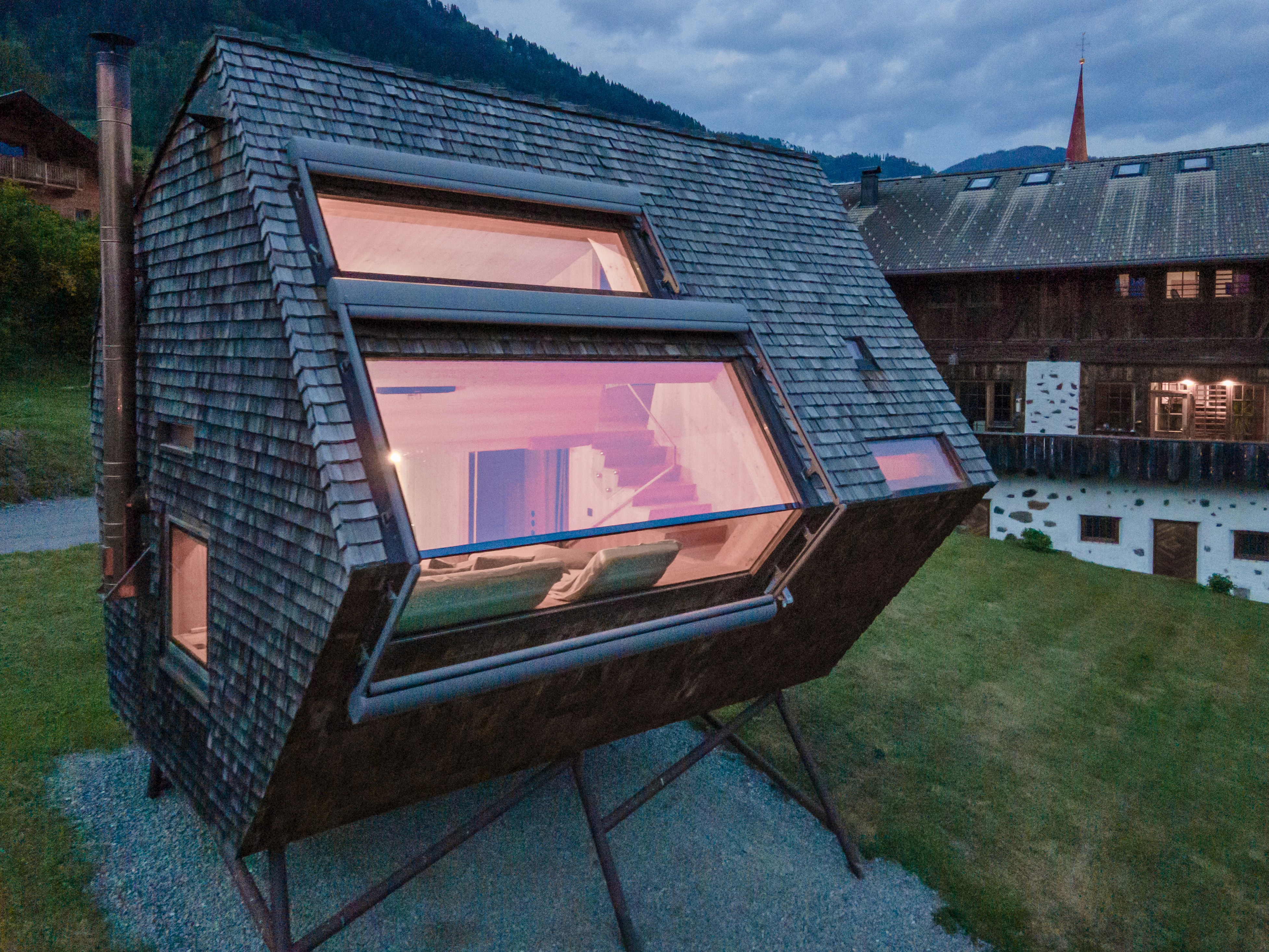 Large panoramic window of Ufogel showcasing its unique wooden architecture and Alpine surroundings