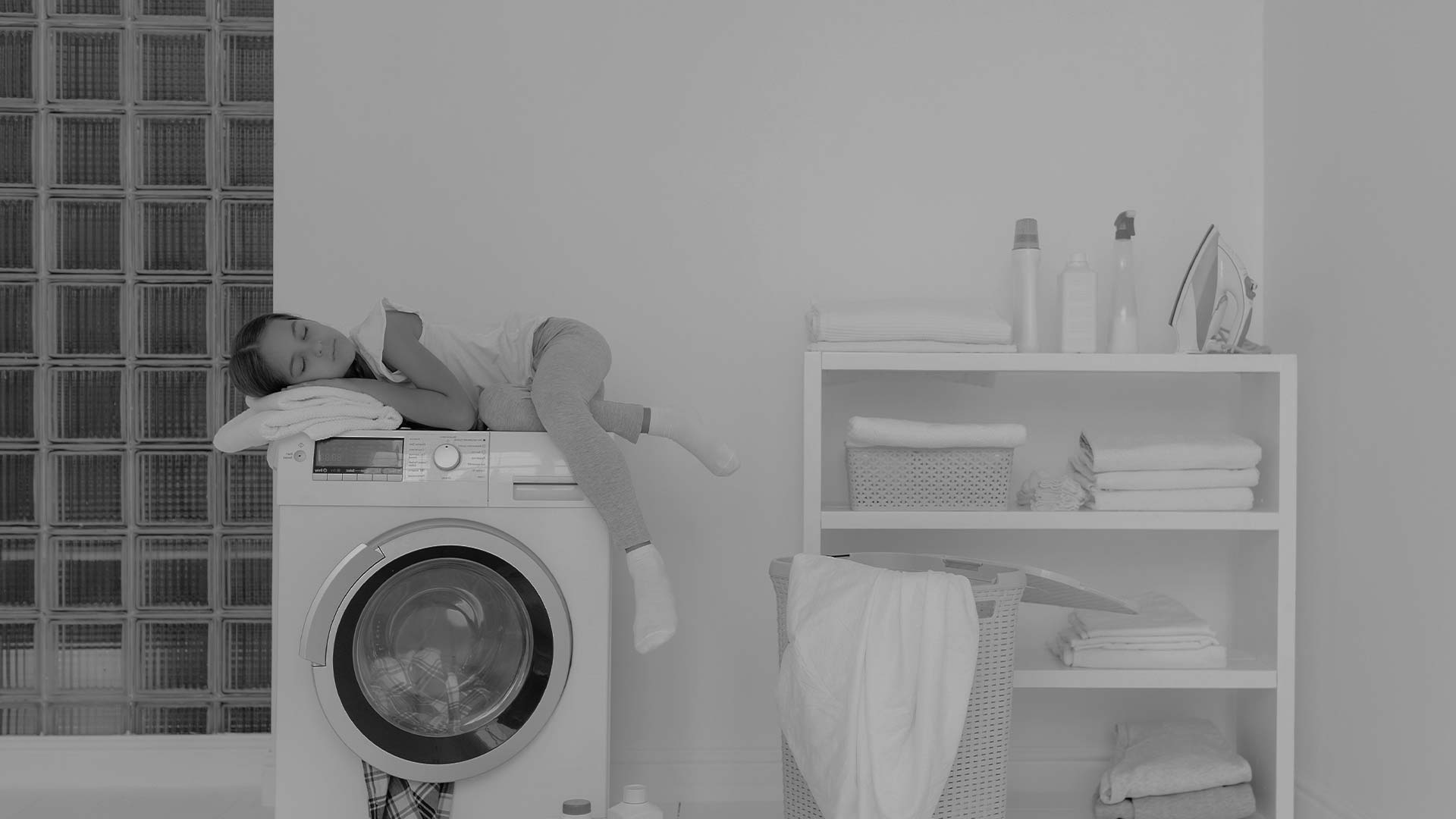 Тиха пральна машина з фронтальним завантаженням, дитина спить зверху – приклад домашнього комфорту