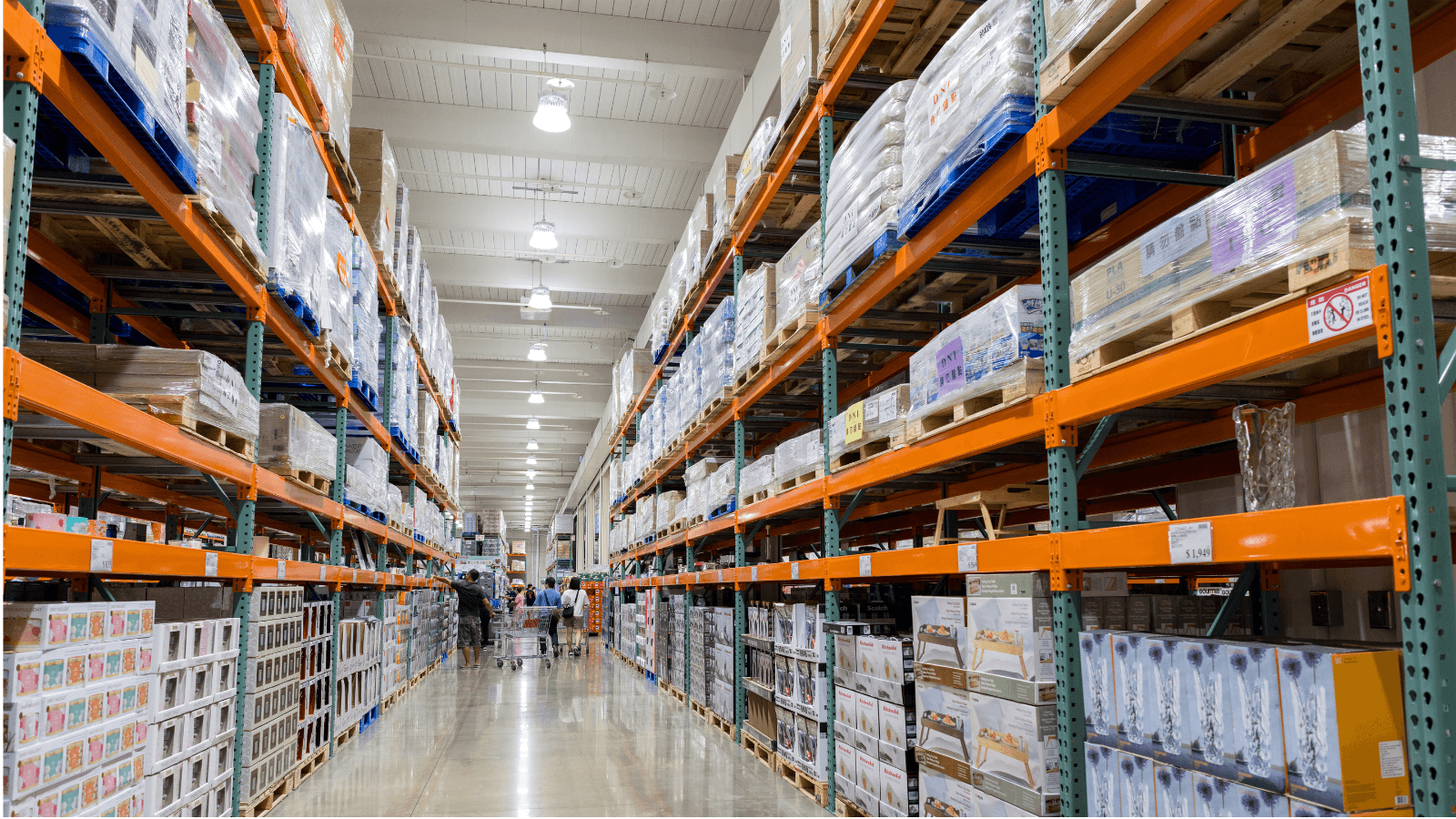 An aisle in a Costco warehouse filled with neatly stacked goods on high shelves, highlighting logistics industry news about their big-and-bulky delivery improvements in 2025