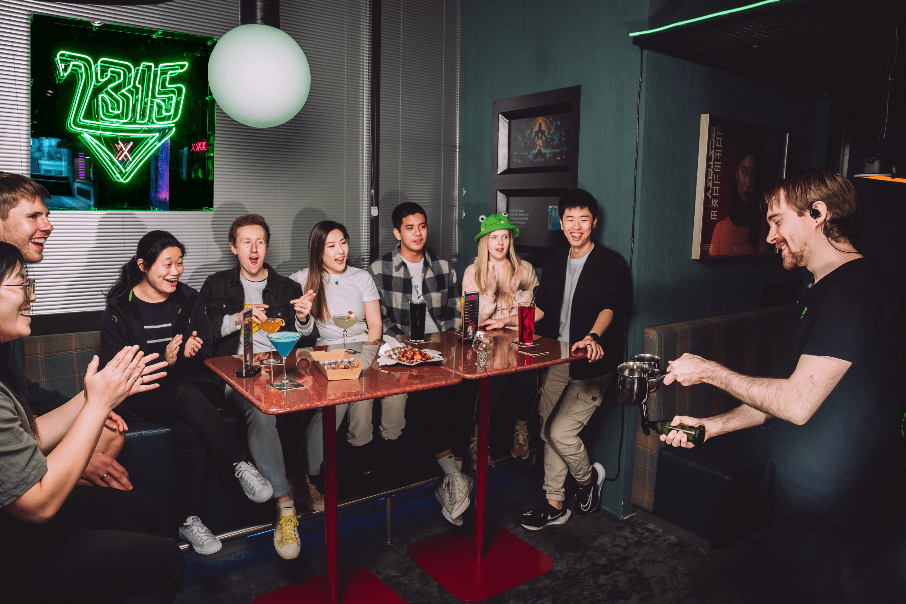 Group of various people sitting in 2315 drinking cocktails