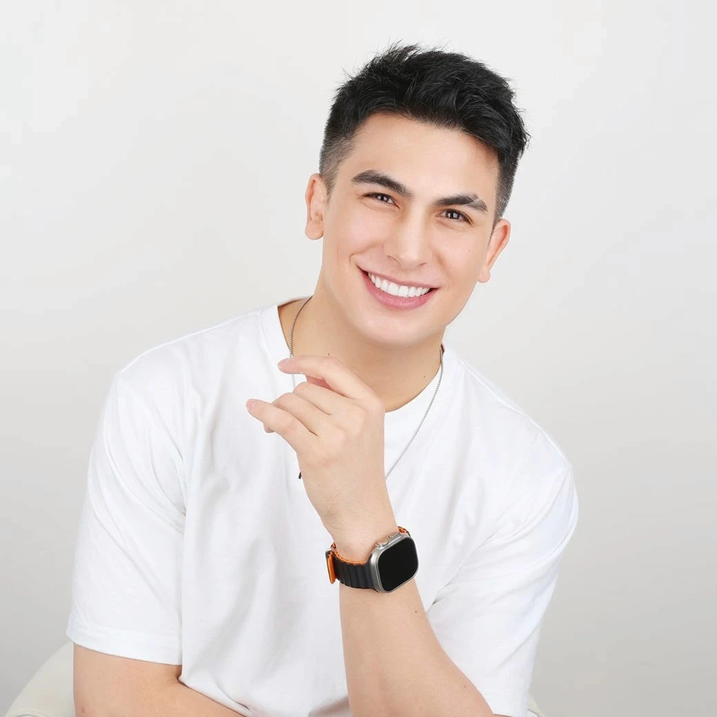 Man in a white T-shirt smiling after ceramic veneer treatment