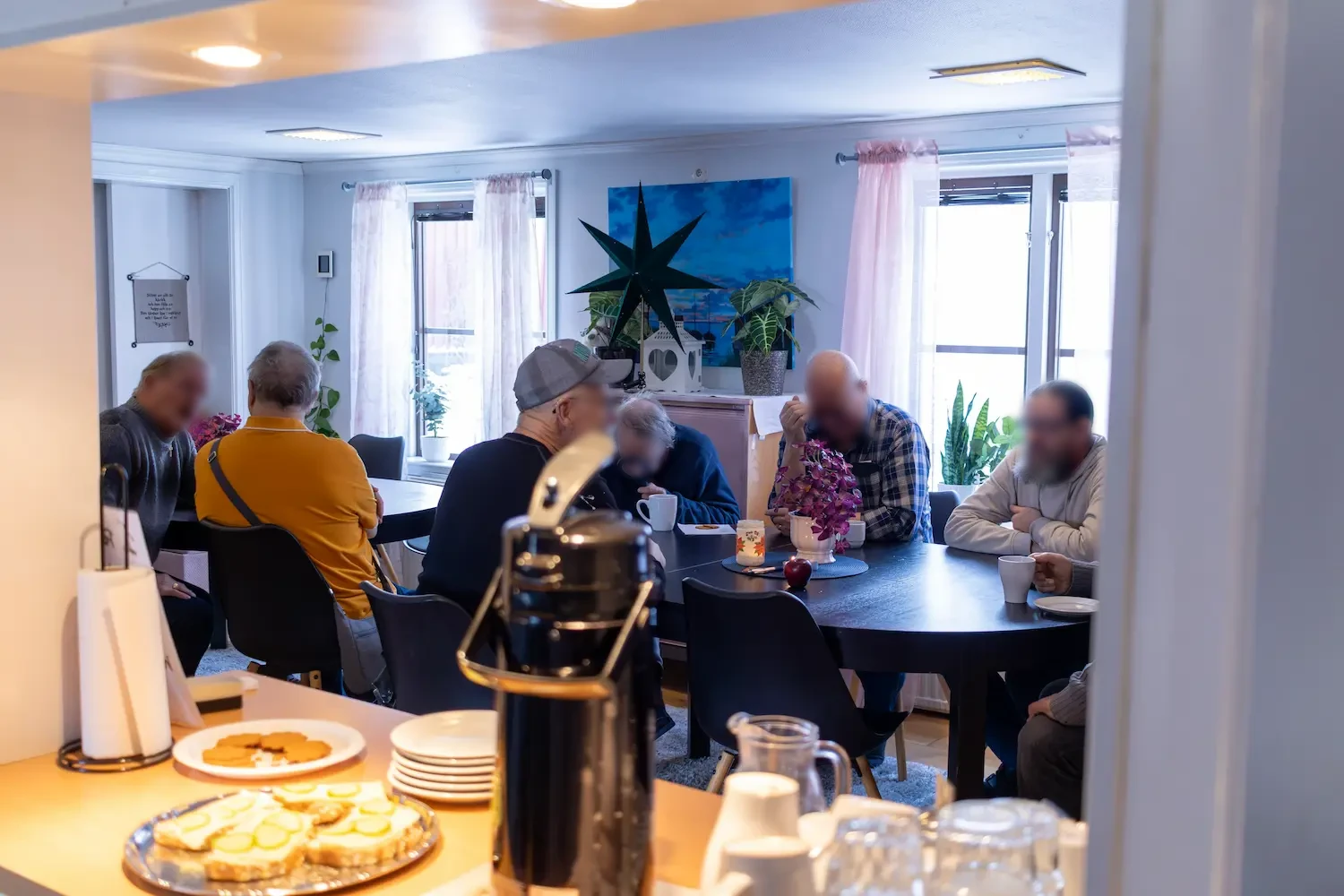 Besökare sitter tillsammans runt ett bord i Vinternatts lokaler.