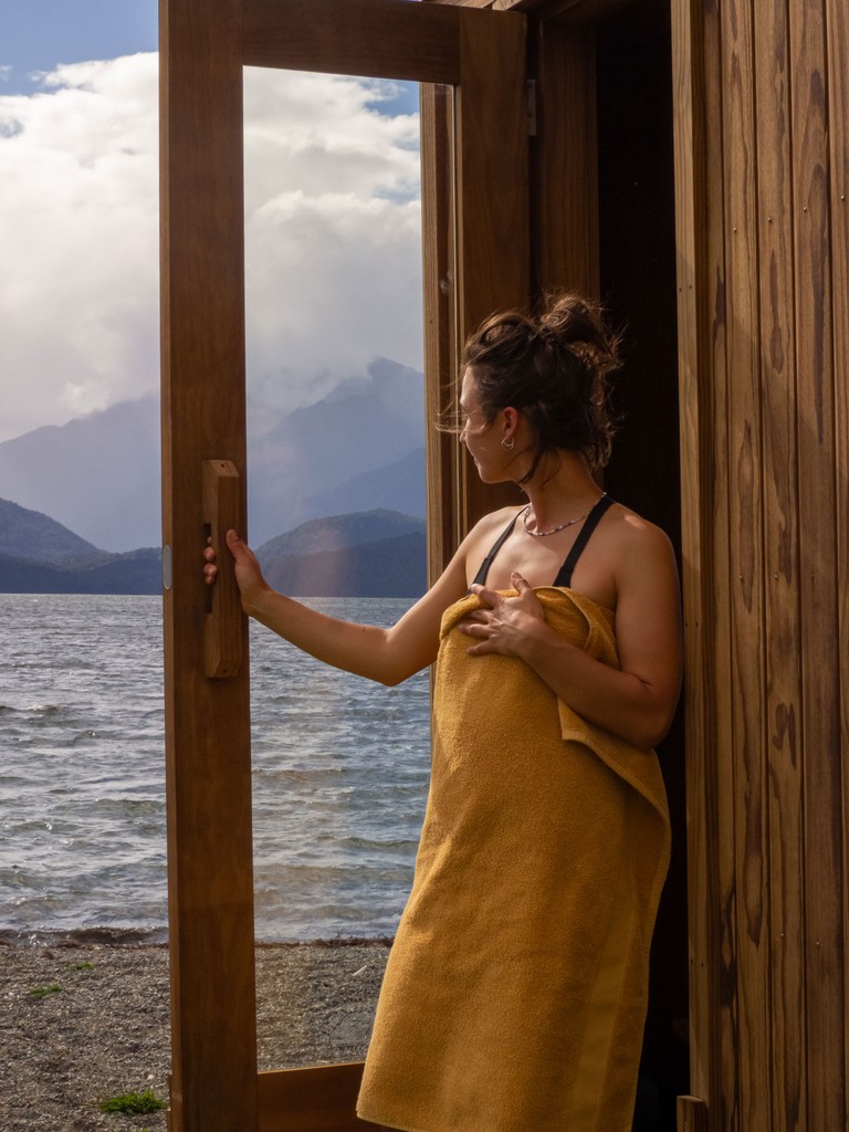 Fireplace in sauna with a lake view in the background