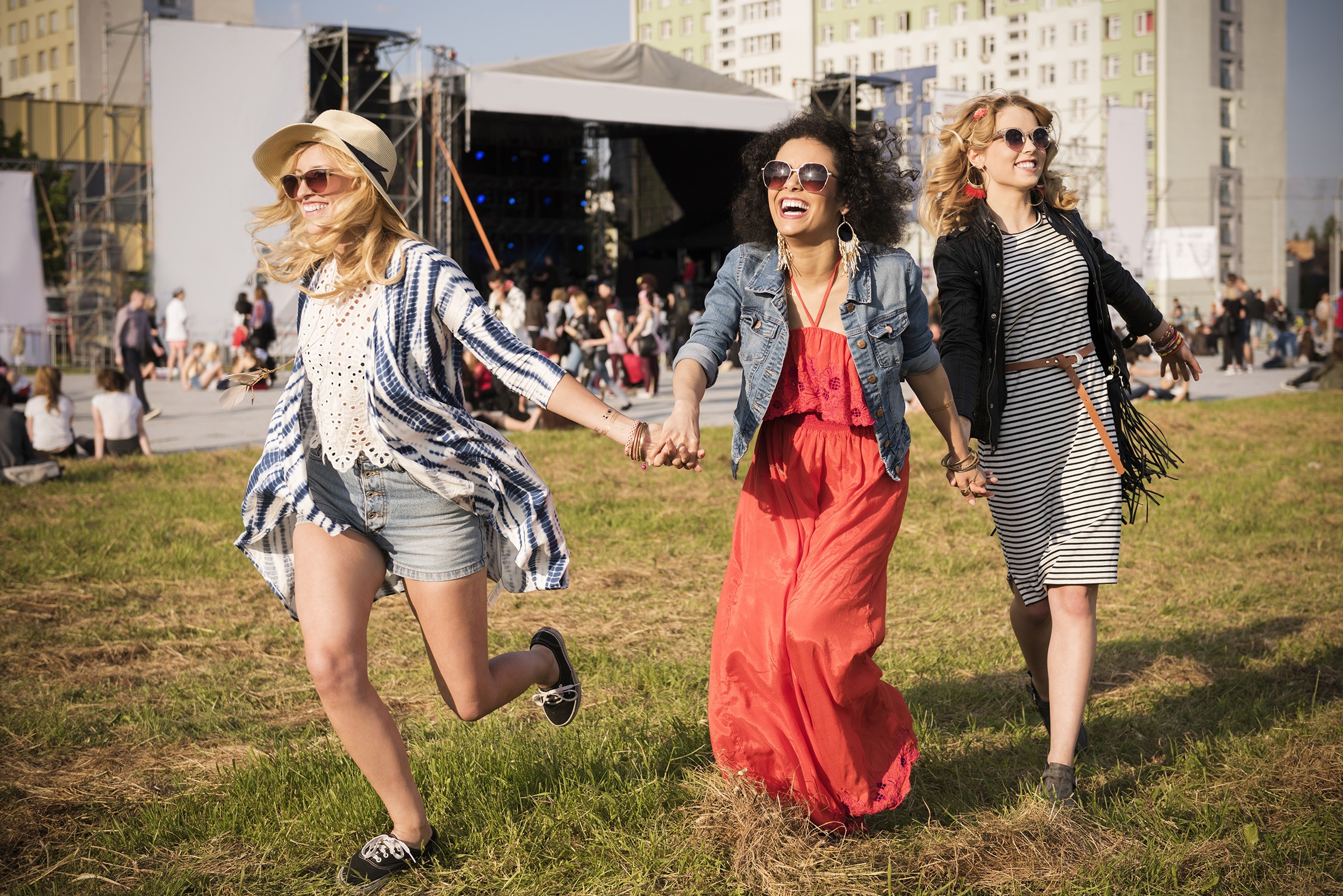 Three women holding hands at outdoor event