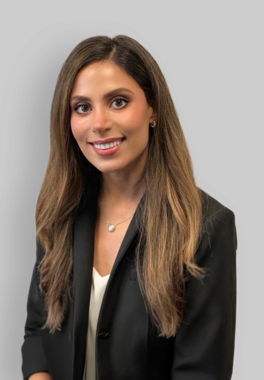 A woman with straight blonde hair wearing a light colored sweater looks away.