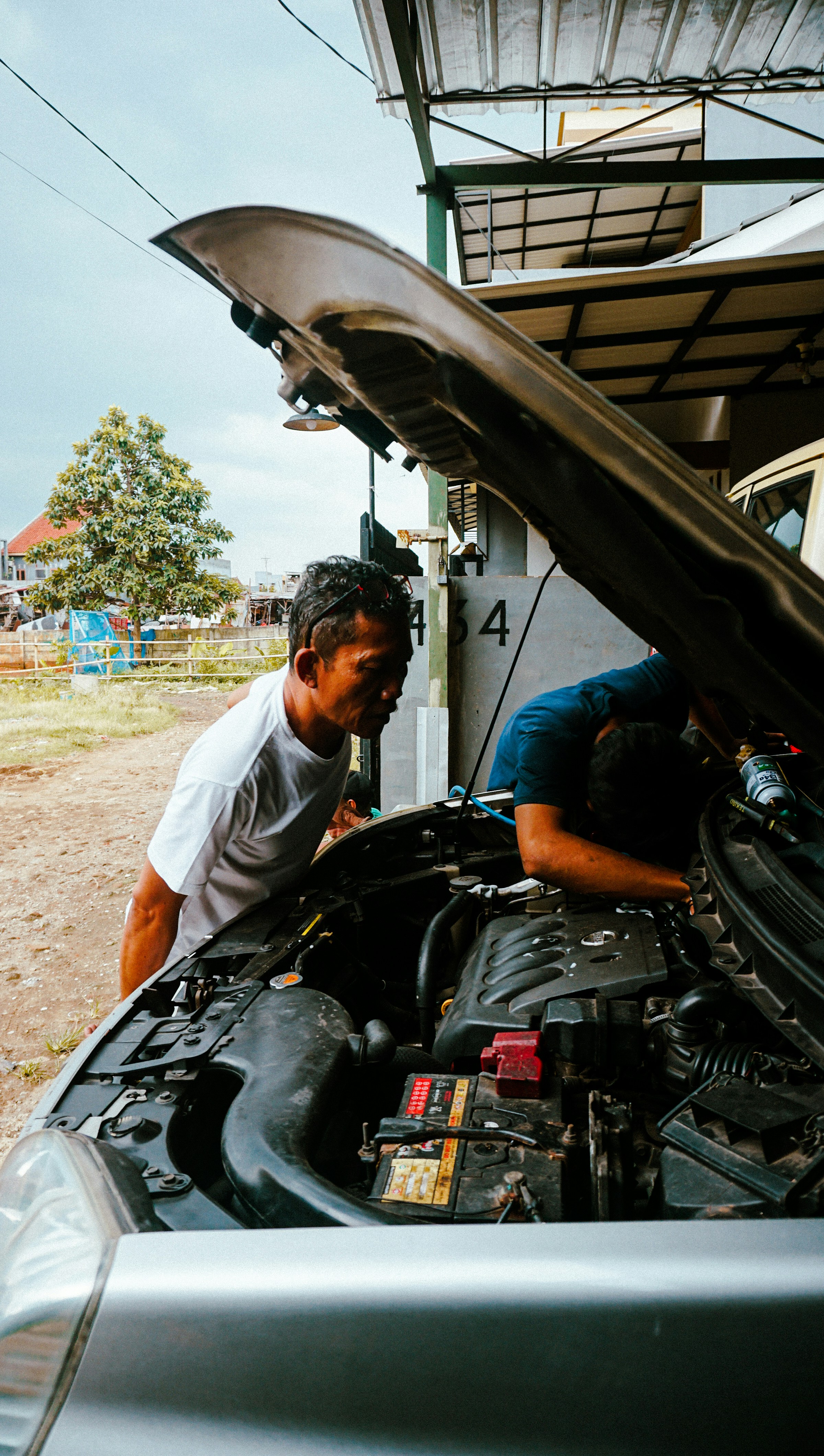 a man working on a car engine in a garage