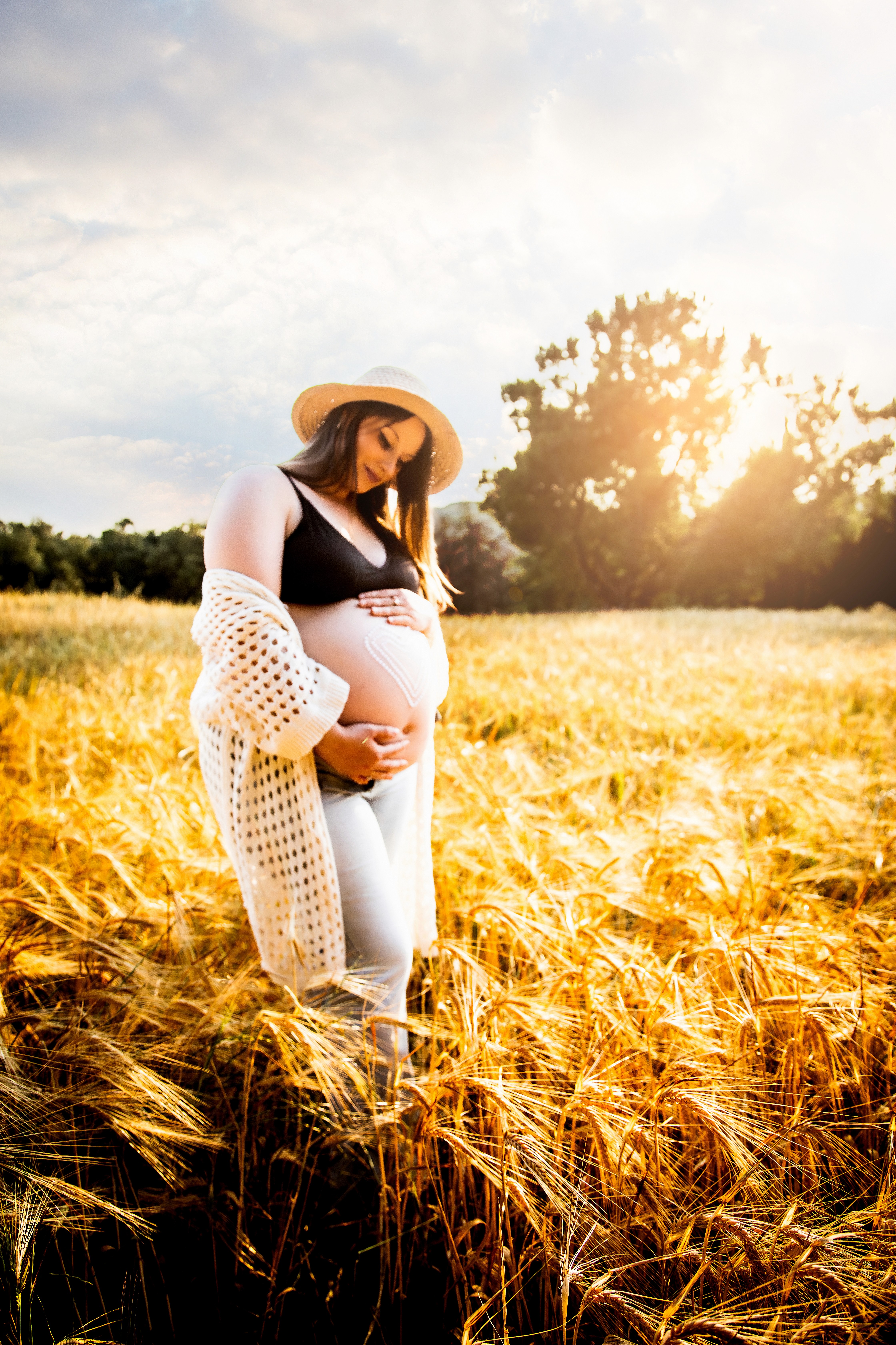 Premamá posando en un campo de trigo