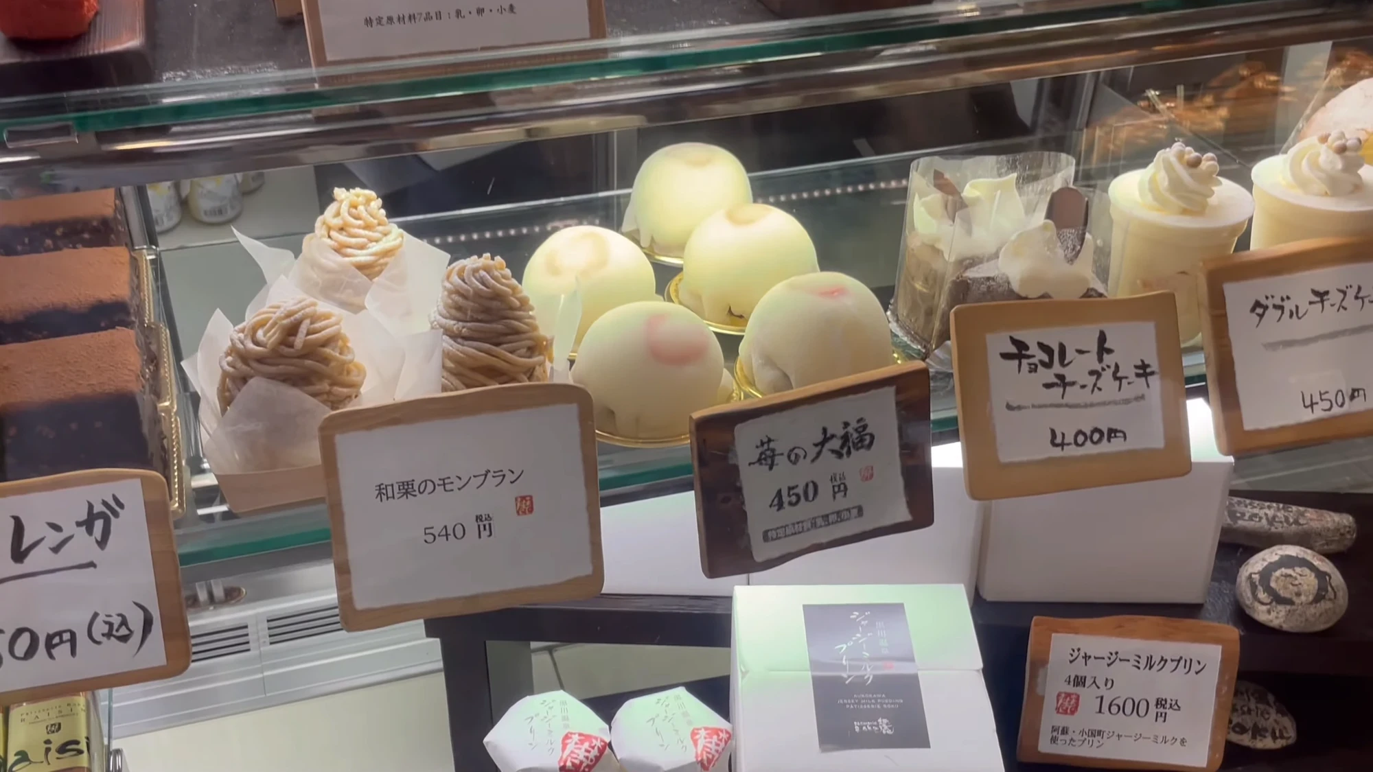 A sweets counter at Kurokawa Onsen with mont blanc and daifuku, each priced on a card