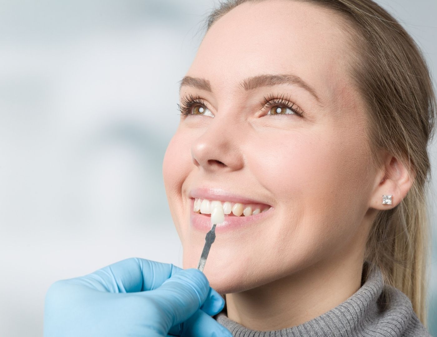 Woman selecting tooth shade for dental veneers