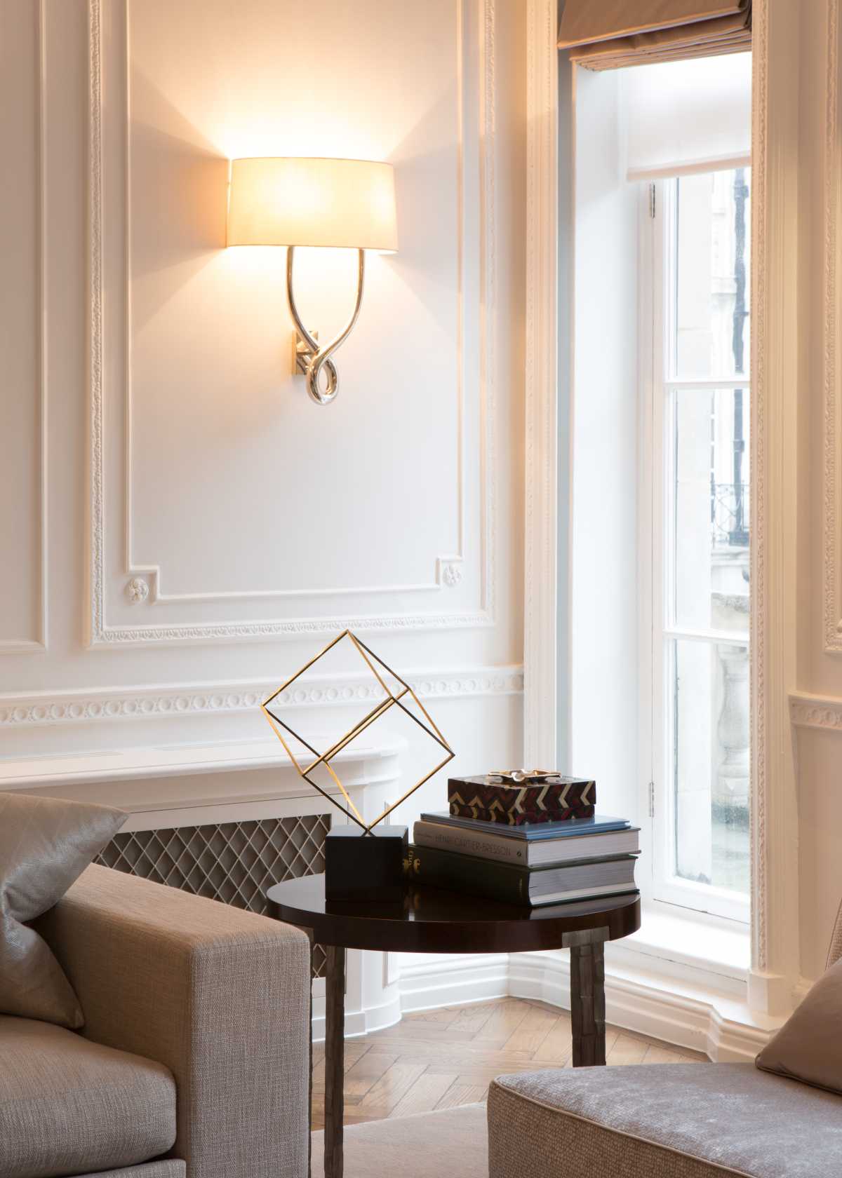 Architectural entryway designed by a bespoke London firm featuring a custom wooden staircase with vertical slatted balustrades and a marble round table.