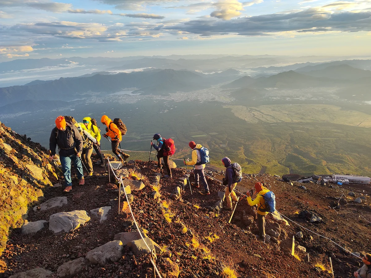 Reisegruppe besteigt einen Berg mit Blick ins Tal