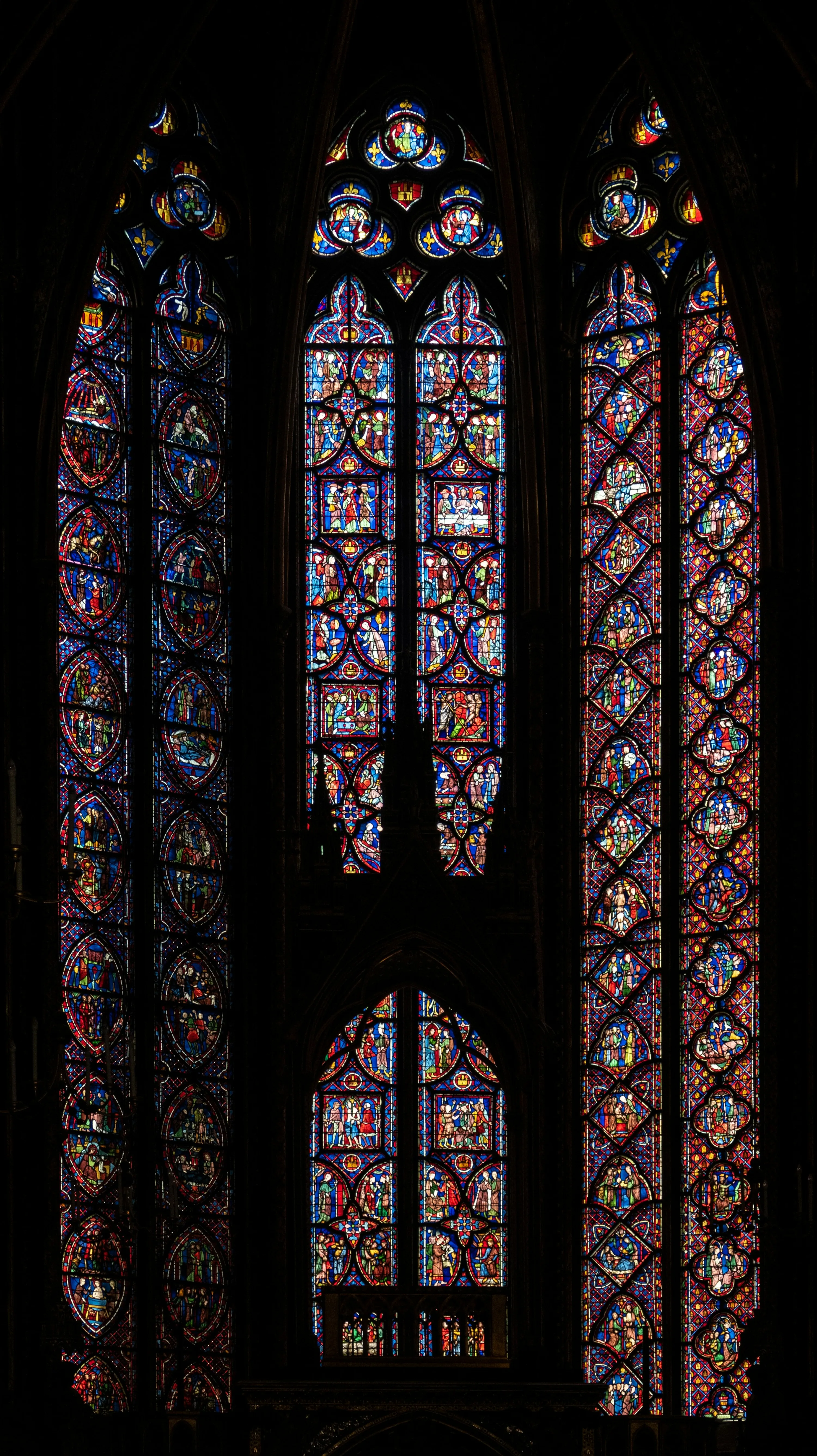 One of the stained glass windows with light shining through in the Sainte Chapelle