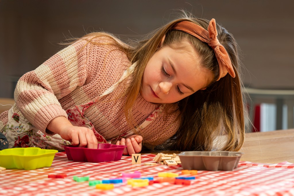 Meisje maakt koekjes aan tafel