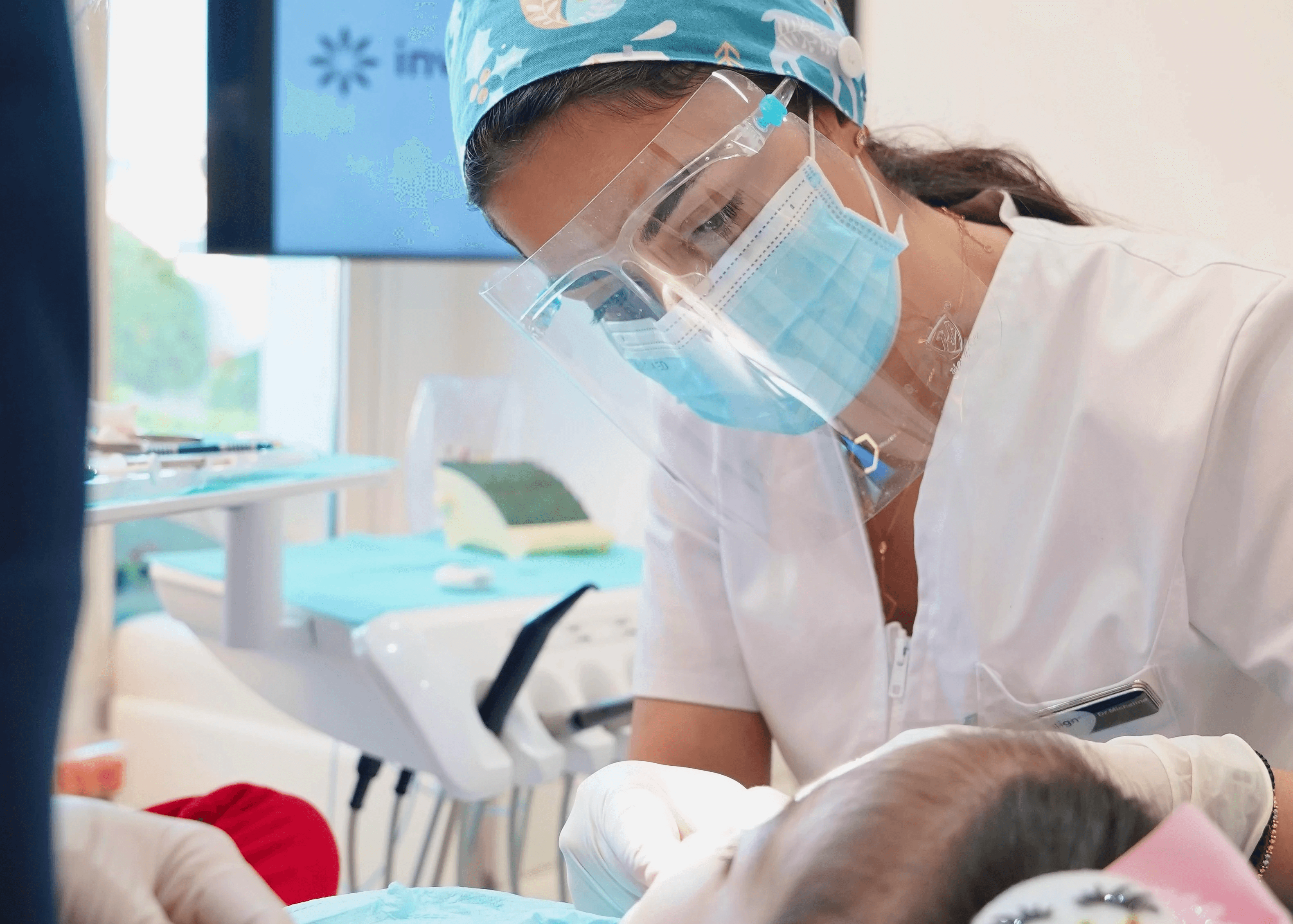 A pediatric dentist carefully examining a kid’s teeth at Invisalign Center