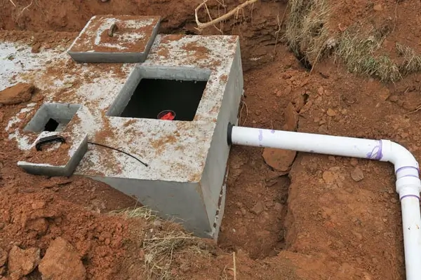 Open septic tank with drainage pipe on a residential property in Cherokee County, GA