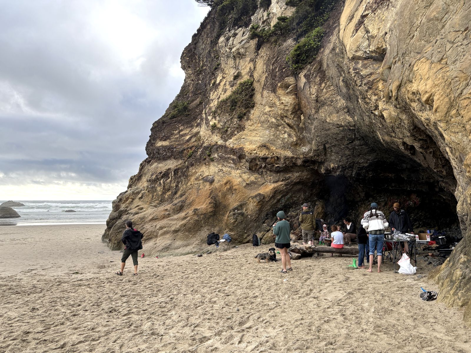 Our extended family cooking dinner over a fire inside the Hug Point beach cave