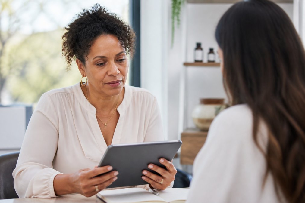 Professional woman reviewing health data on a tablet for her personalized hormone optimization for high performers.
